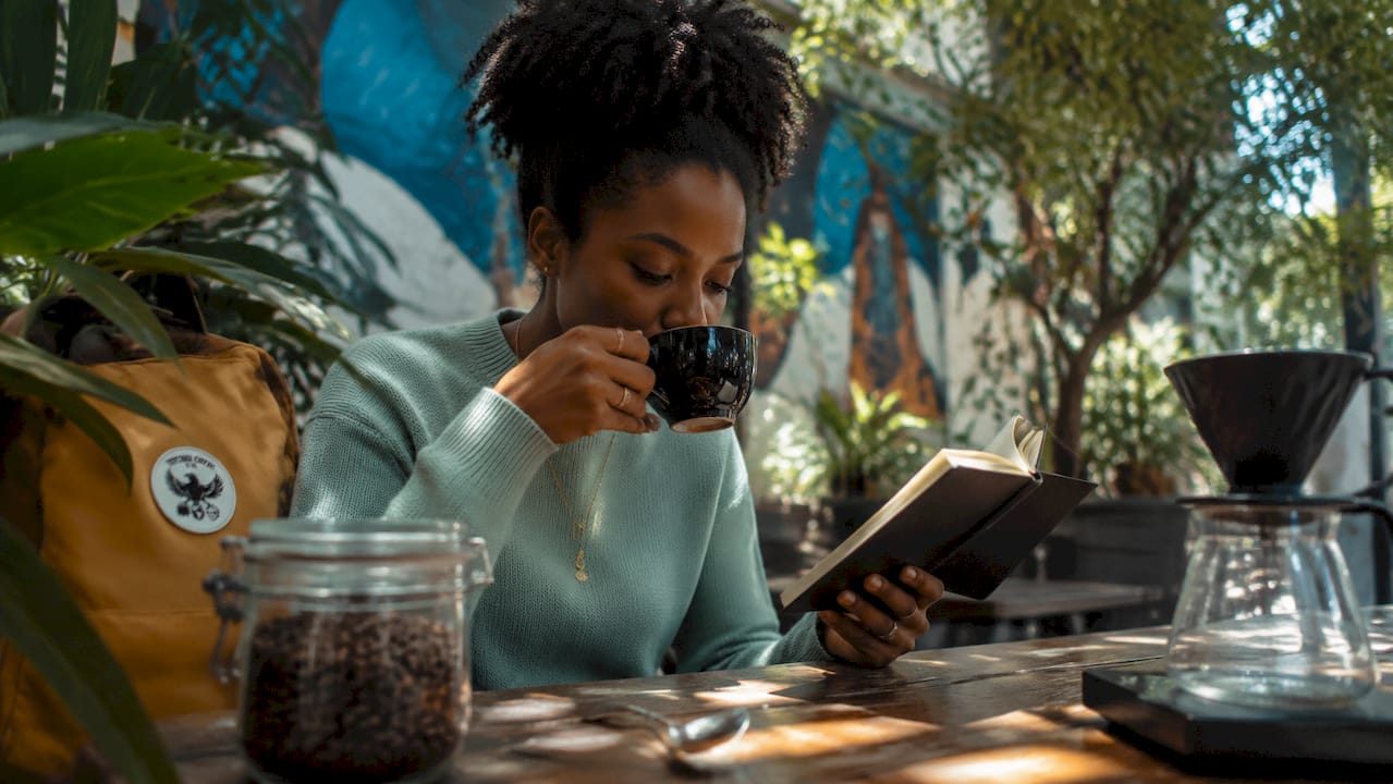 Woman tasting single estate coffee in café